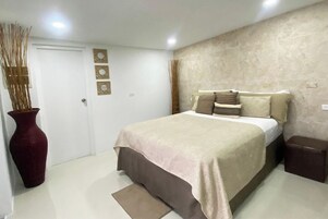 Un dormitorio con una cama, un florero y una puerta.