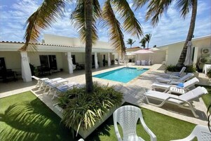 Una piscina al aire libre, sillones reclinables de piscina