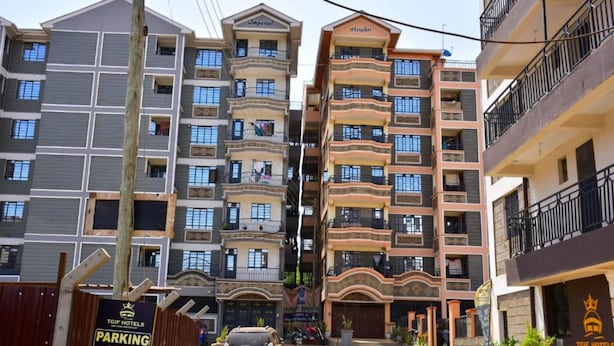 A multi-story hotel with balconies, a parking area sign, and a clear sky. - Stay.Plus 1 bedroom Imperial Heights (Ruiru)
