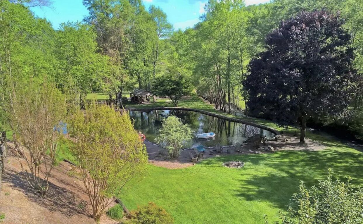 A serene park with a pond, a small bridge, and a gazebo.