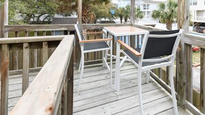 A wooden deck with a table and chairs. - 3BR Walk to the Beach House in Surfside Beach! Looney Dunes (Surfside Beach)