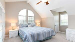 A bedroom with a large bed, two bedside tables, a ceiling fan, and two windows. - 3BR Walk to the Beach House in Surfside Beach! Looney Dunes (Surfside Beach)