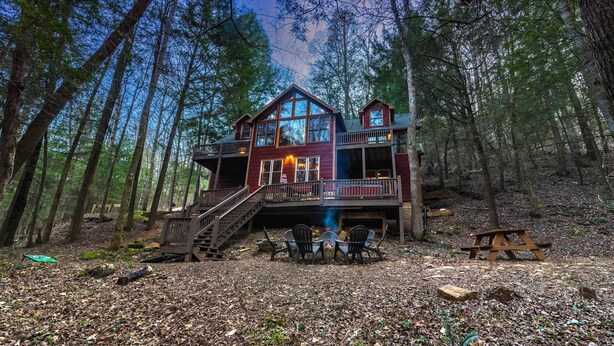 A cabin with a deck, surrounded by trees. - Private - Creekside - Cabin + Hot Tub/Pool Table & Pet Friendly (Ellijay)