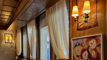 A restaurant with wooden tables and chairs, a menu board, and decorative wall sconces.