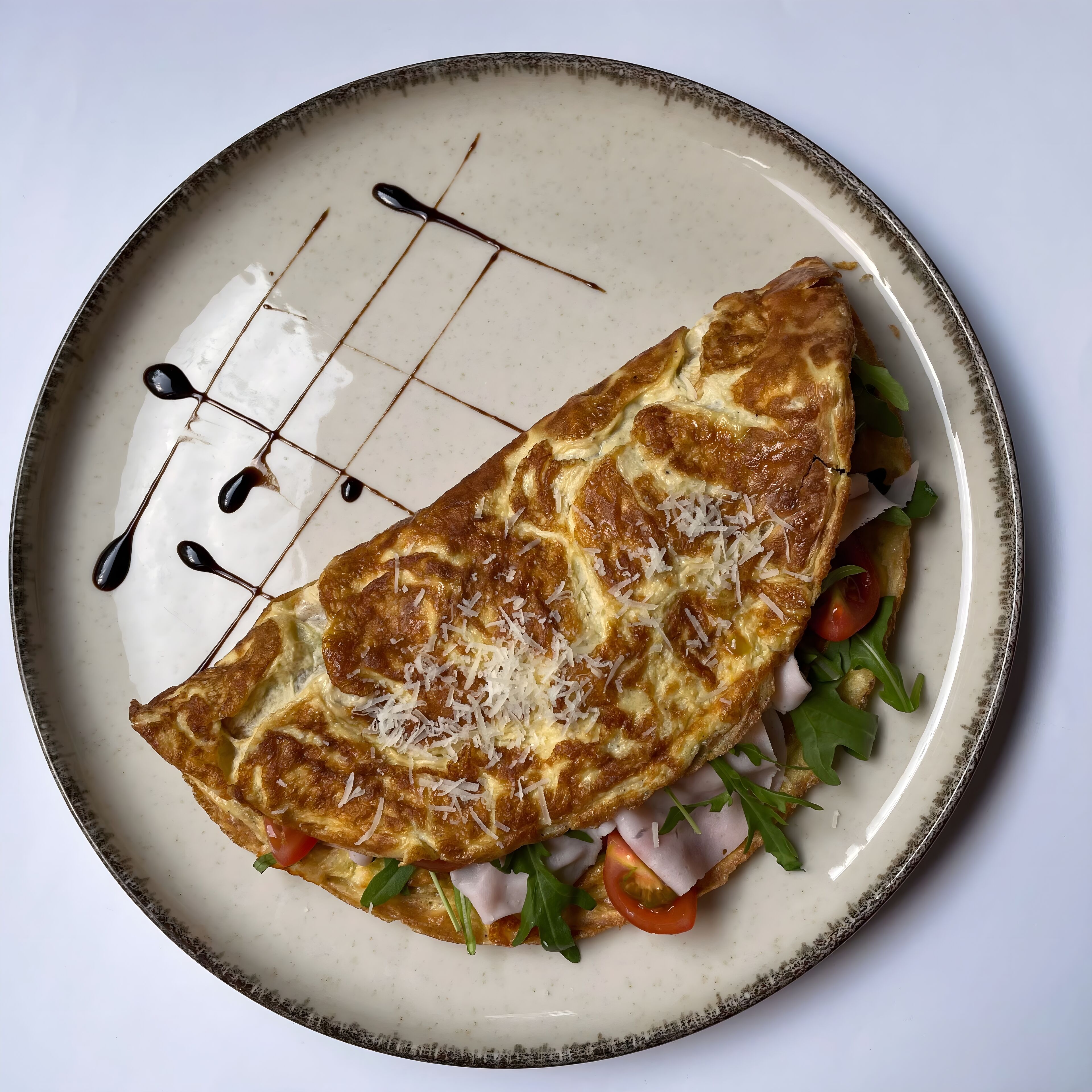 Un plato con una tortilla enrollada, tomates, lechuga y queso.