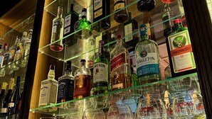 Un bar con botellas de licor y vasos.