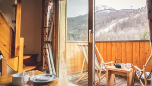 A wooden cabin with a balcony overlooking a mountainous landscape. - Le Serre d'Or, large apartment at the foot of the slopes (Saint-Chaffrey)
