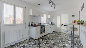 Una cocina moderna con armarios blancos, una isla central y un suelo con diseño.