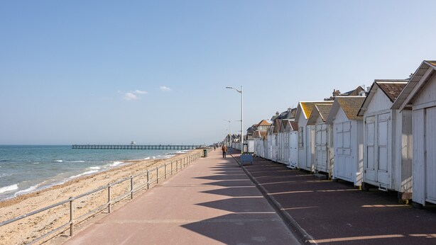 A coastal promenade with a beach, a pier, and row houses along the water. - Callisto - Appartement Vue Mer (Luc-sur-Mer)