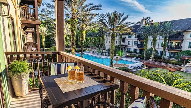 Ein Balkon mit Tisch, zwei Stühlen und einem Blumentopf.
