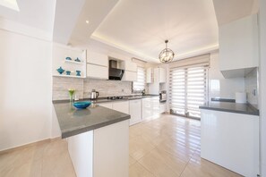A modern kitchen with white cabinetry, a granite countertop, and a central island.