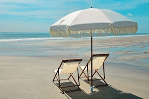 A beach with two beach chairs and a large white umbrella. - 6204-1 balcony-no carpet-full kitchen-W/D-cable-community pool & hot tub (St. Augustine)