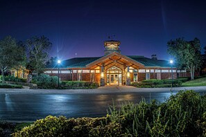 A well-lit hotel entrance with a prominent tower, paved driveway, and landscaped surroundings. - 6204-1 balcony-no carpet-full kitchen-W/D-cable-community pool & hot tub (St. Augustine)