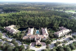 A large resort with multiple buildings, a central pool, and a surrounding forested area. - King Suite w/ kitchenette & full size fridge -55 in TV cable -pool & hot tub! (St. Augustine)