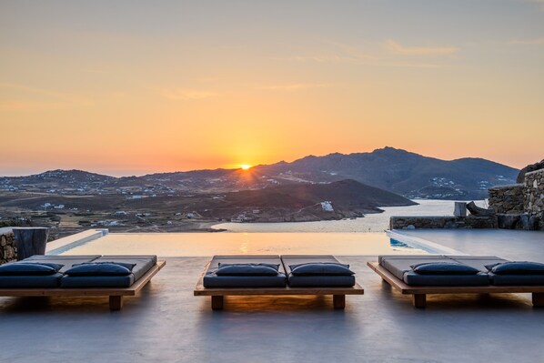 An infinity pool, a heated pool, sun loungers