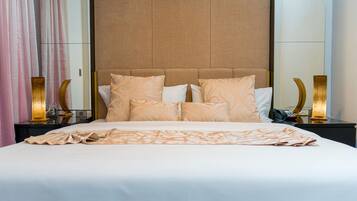 A neatly made bed with a patterned bedspread, a headboard, and bedside lamps on a nightstand.