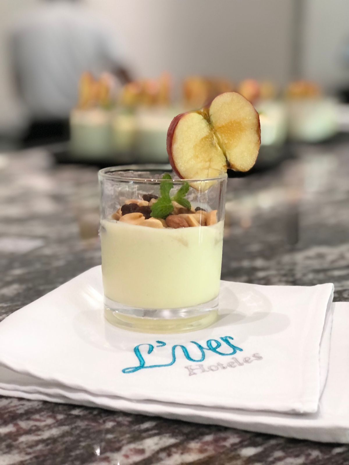 A dessert in a glass on a white napkin with the text "L'Inver Hotels".