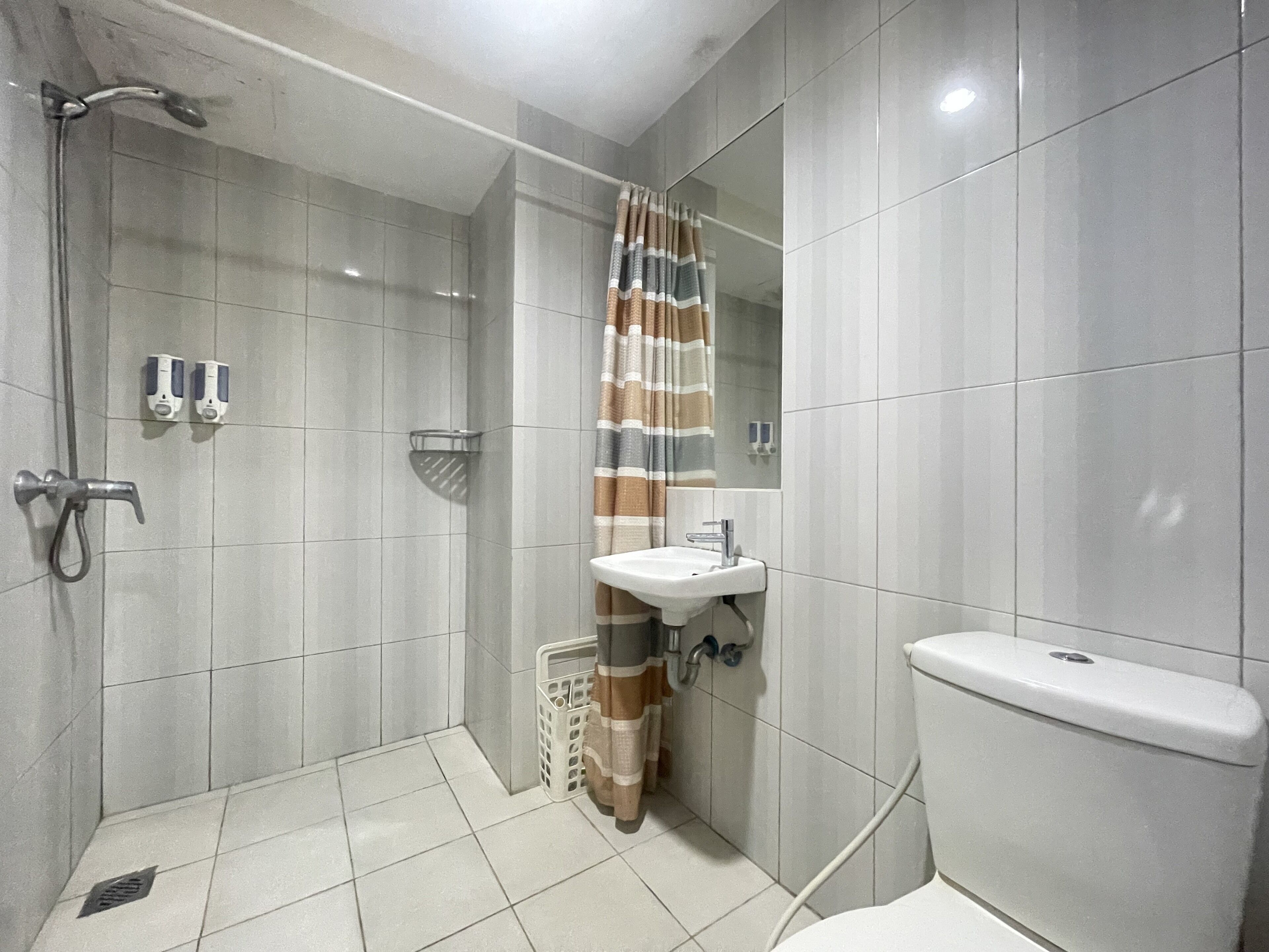 A bathroom with a shower, toilet, and sink.