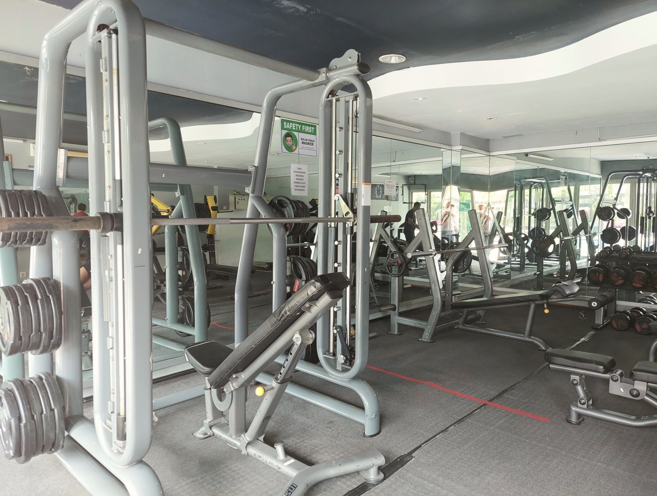 A gym with various exercise equipment, including weight machines and free weights.