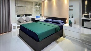 Un dormitorio moderno con una cama grande, mesitas de noche, un espejo y un armario empotrado.