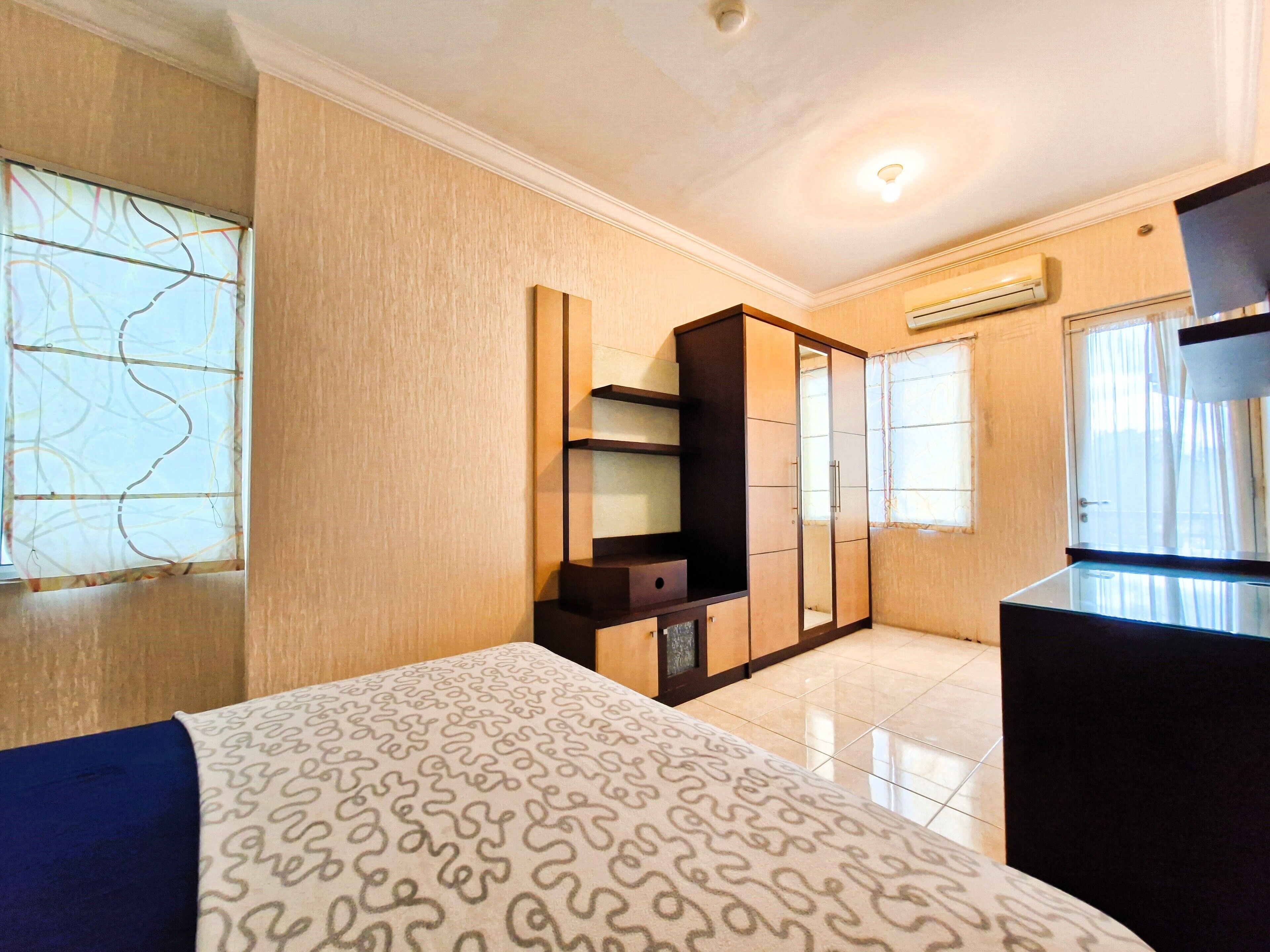 Ein Hotelzimmer mit Bett, Kleiderschrank, kleinem Tisch und Fernseher.