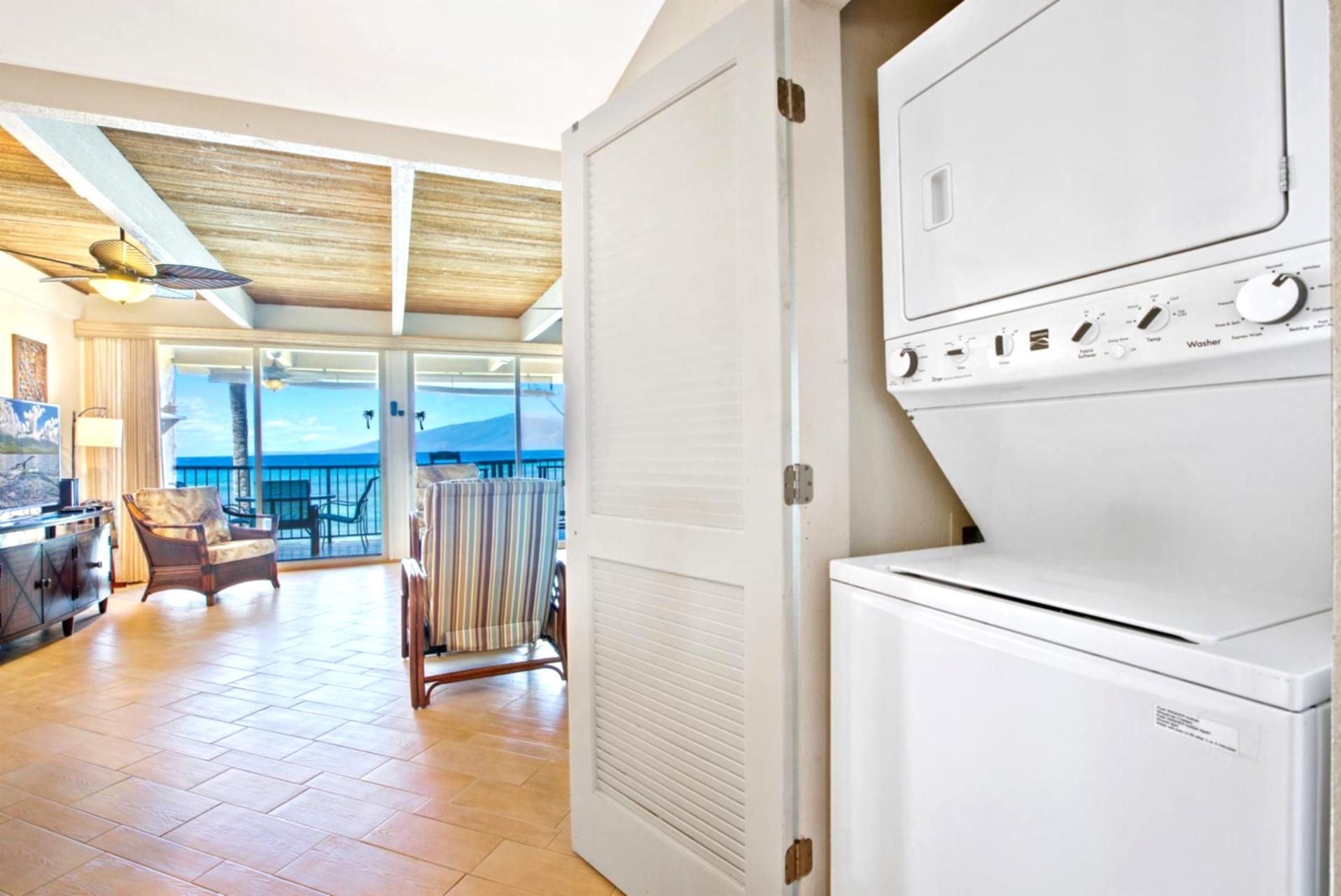 A hotel room with a balcony, a washer and dryer, a dining area with a view, and a ceiling fan.
