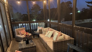 A covered outdoor seating area with wicker furniture and a view of the outdoors. - Experience North Ocean City near the sandy shores (Ocean City)