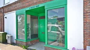 A building with a green entrance and a sign above the door. - Station 1 Bed Apartment – Stayseekers (Wiltshire)