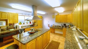 Una cocina moderna con encimeras de granito, armarios de madera y una isla central.
