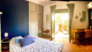 Ein Schlafzimmer mit einem Bett, einem Schreibtisch, einem Fernseher und einem Kleiderschrank.