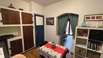 A cozy room with a dining table, a bookshelf, and a blue door.