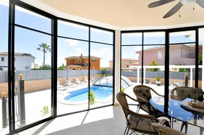 A room with large windows overlooking a swimming pool and neighboring houses. - Beautiful spacious holiday home for families with a big swimming pool and garden - Free Wifi (Marratxi)