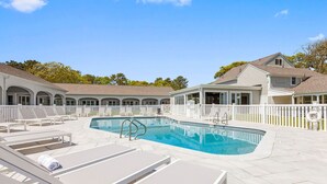 A swimming pool with lounge chairs and a covered seating area. - Pelham on Earle (West Harwich)