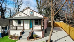 A two-story house with a front porch, a garage, and a well-maintained lawn.