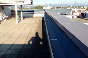 Terraço no terraço com vista para uma ponte e montanhas ao longe.