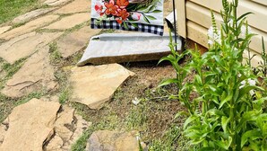 A house with a covered porch, stone steps, and a banner that reads "Bless our Nest". - Our Nest, a well loved quiet retreat in Foxwood Hills Resort near Lake Hartwell. (Westminster)