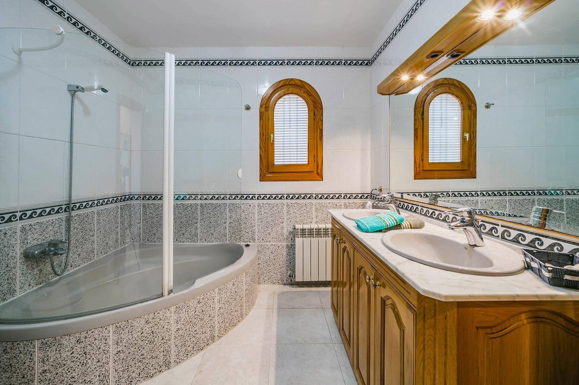 Ein Badezimmer mit einer freistehenden Badewanne, einem Waschbecken und einem Waschtisch mit Spiegel.