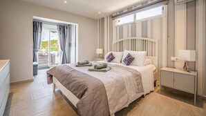 A bedroom with a bed, bedside tables, a window, and a view of the outdoors. - Villa Tomillo by Villa Plus (Jávea)
