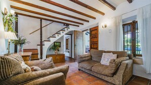 Un salon avec un escalier, un canapé et une lampe.
