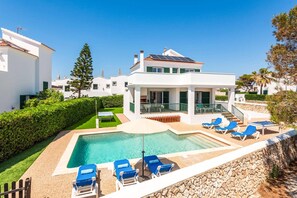 A modern villa with a swimming pool, lounge chairs, and a covered patio area. - Villa Natasha by Villa Plus (Los Delfines)