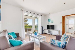 A modern living room with a sofa set, a coffee table, and a flat-screen TV. - Villa Natasha by Villa Plus (Los Delfines)