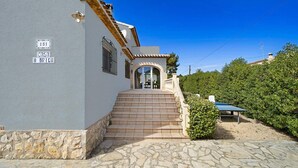 A building with a stone staircase leading to a door, a sign reading 'CASA O BRIEN,' and a clear blue sky. - Villa Toscamar by Villa Plus (El Tosalet)