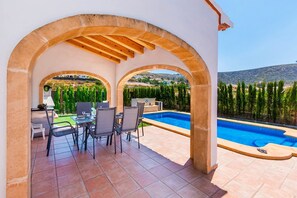 A covered outdoor area with a pool, seating, and a view of the landscape. - Villa Jean Ingres by Villa Plus (Jávea)