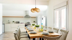 Una cocina moderna con armarios blancos, una campana extractora de acero inoxidable y un horno empotrado.