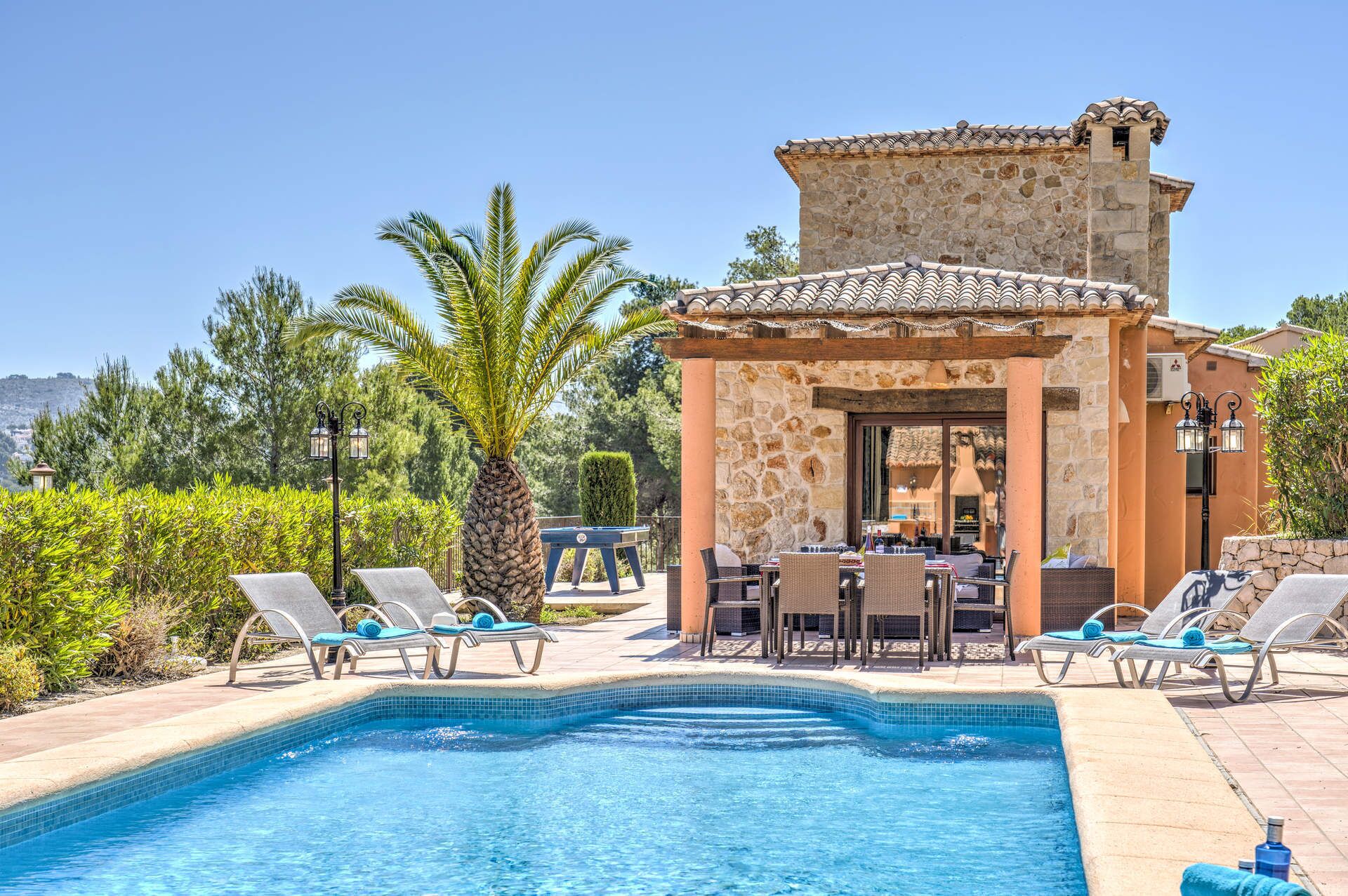 A pool area with lounge chairs and a covered seating area.