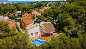 Zona residencial a la costa amb cases, una piscina i vistes al mar.