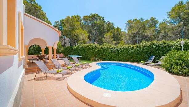 Una piscina rodona amb gandules i una zona de seients coberta.