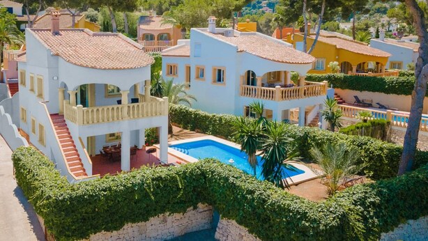 A residential area with multiple houses, a swimming pool, and lush greenery. - Villa Ciruela by Villa Plus (El Tosalet)