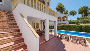 A poolside area with a staircase leading to a covered patio. - Villa Ciruela by Villa Plus (El Tosalet)