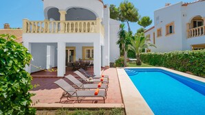 A poolside area with lounge chairs and a pool. - Villa Ciruela by Villa Plus (El Tosalet)